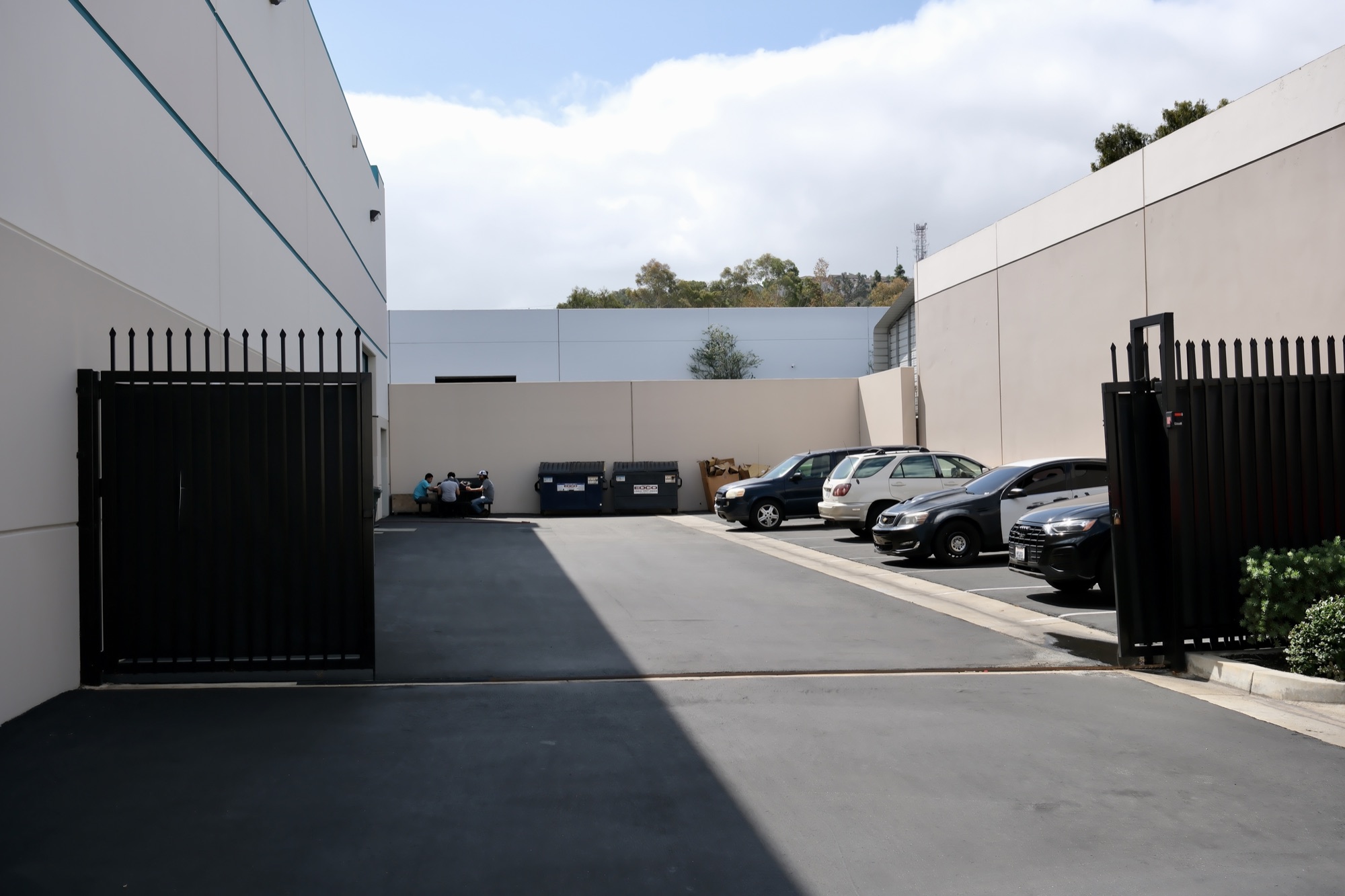 Gated rear yard behind 2695 Temple Ave with dumpster enclosure and tenant parking